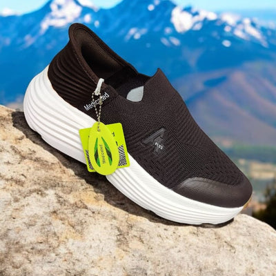 Black and white sneaker with a green tag on a rock with mountains in the background, labeled '100% Medicated'.